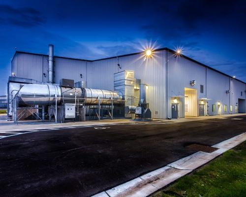 Back side of MAAS Aviation Painting Facility showing metal piping at night.