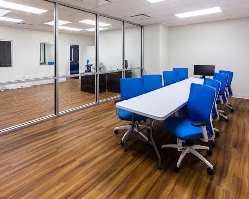 Conference room inside MAAS Aviation Painting Facility. Large room with conference table and blue chairs in the center.